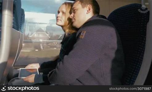 Timelapse of young happy couple traveling by rail and using tablet computer to make selfie. Memory shots during the trip