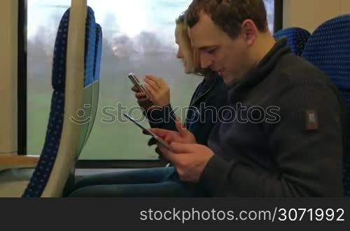 Timelapse of young man and woman spending time in the train with tablet PC and smart phone. Comfortable and enjoyable traveling