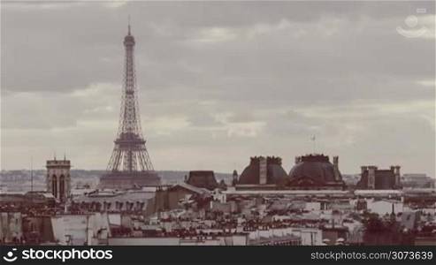 Timelapse shot of grey clouds floating over the Paris with following zooming in Eiffel Tower