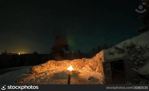 Timelapse shot of northern lights in night sky. Viewing natural phenomenon from the ground near the fire