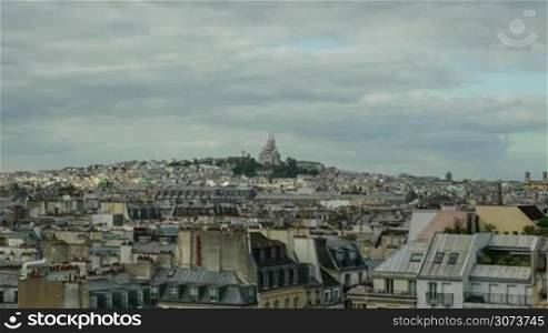Timelapse shot of Paris panorama with clouds moving and sun rays walking over the city reaching the Sacre Coeur Basilica in the distance