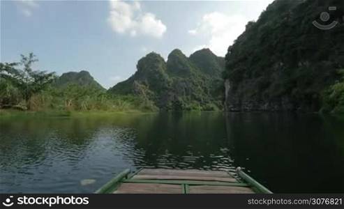 Timelapse shot of river boat tour among the limestone mountains in Trang An Landscape Complex, Vietnam