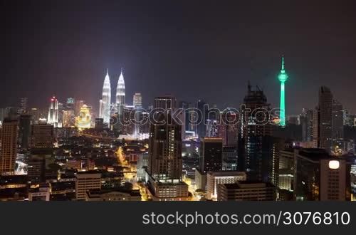 Timelapse shot with zooming in of Kuala Lumpur at night. Capital of Malaysia with illuminated skyscrapers, Petronas Twin Towers and Menara KL Tower