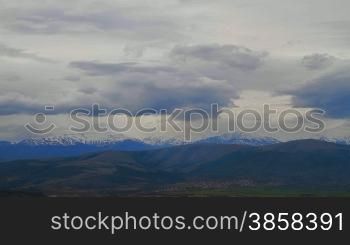 Timelapsed countryside landscape with mountain hills covered by snow