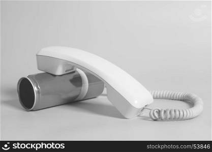 Tin can phone with handset on gray background