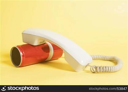 Tin can phone with handset on yellow background