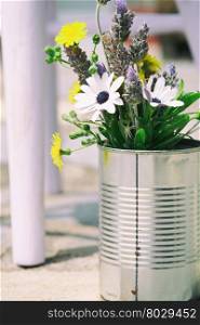 Tin can used as a vase with flowers