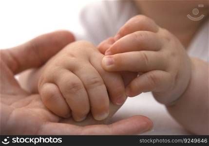 Tiny baby hands holding mothers finger close up