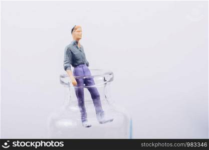 Tiny figurine of man miniature model coming out of bottle