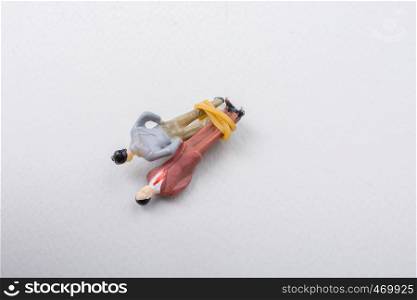 Tiny figurine of men model wrapped in rope