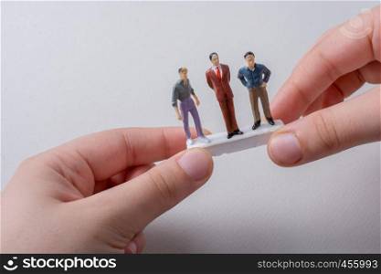 Tiny figurines of men miniature model in hand