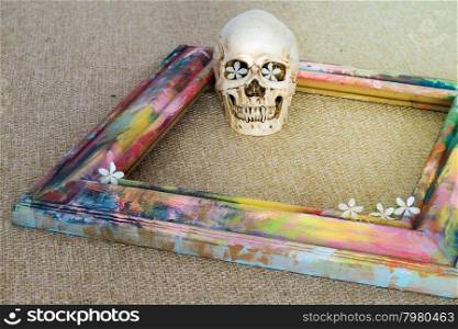 Tiny skulls with colorful wooden frame and Wrightia religiosa flower