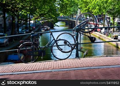 Tipical bicycles parking in Amsterdam, in front of a tipica canal