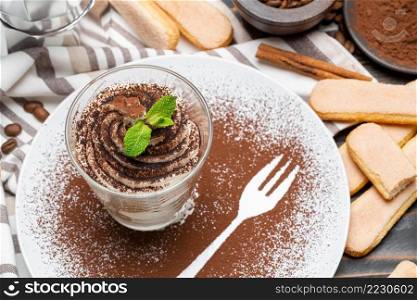 tiramisu dessert cooking - Traditional Italian Savoiardi ladyfingers Biscuits and cream in glass baking dish on concrete background or table. tiramisu dessert cooking - Traditional Italian Savoiardi ladyfingers Biscuits and cream in glass baking dish on concrete background