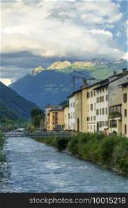 Tirano, Sondrio province, Valtellina, Lombardy, Italy old houses along the Adda river with mountains in background