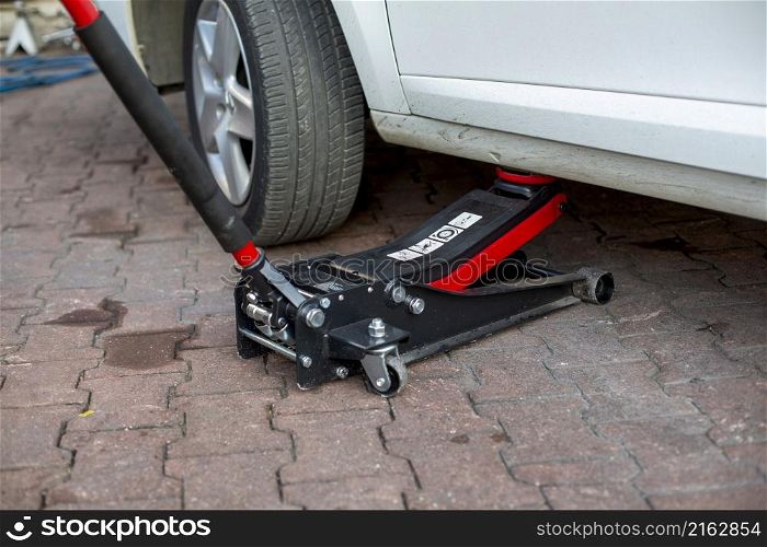 Tire change of a car. placing a jack under the car