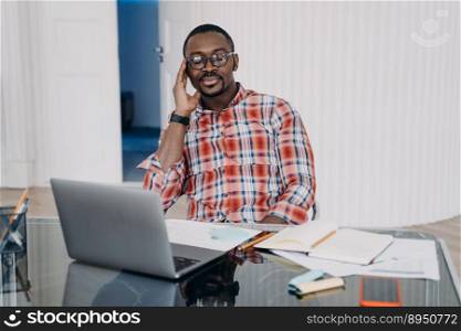 Tired african american male worker with closed eyes hold head with hand relax, have a break at workplace. Pensive black man at laptop collect thoughts together before work to increase productivity.. Tired african american man closed eyes holding head by hand have a break at workplace at laptop