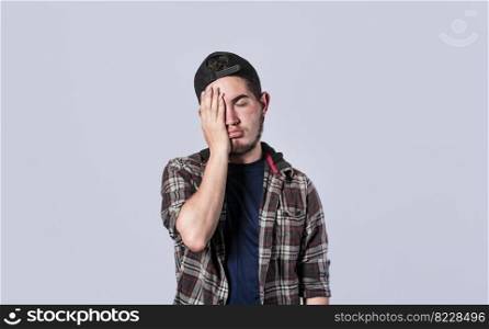 Tired and distressed man covering his face with his palm, Concept of a bored and tired man