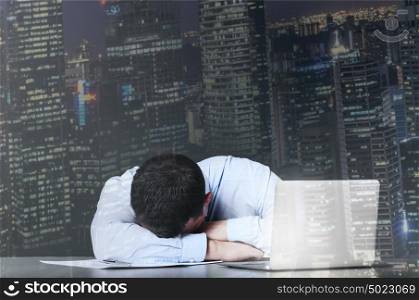 Tired business man is sleeping at his table with laptop. Exhausted businessman sleeps