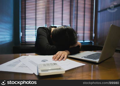 Tired business woman sleeping / take a nap in a office with laptop and financial documents