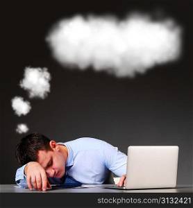 tired businessman is sleeping at his table with laptop and a cloud above his head