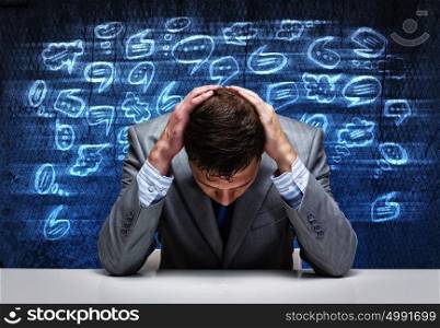 Tired businessman. Troubled young businessman covering head with hands