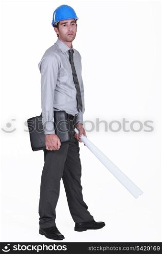 tired businessman wearing helmet and holding a blueprint