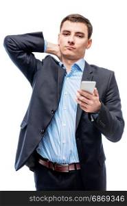 Tired businessman with phone in hand on white background