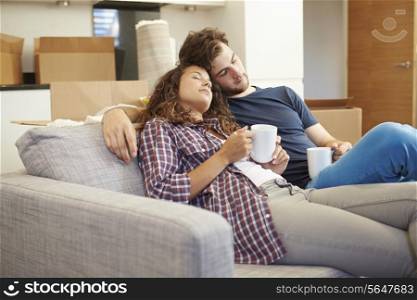 Tired Couple Relaxing On Sofa In New Home