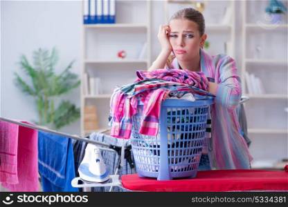 Tired depressed housewife doing laundry. The tired depressed housewife doing laundry