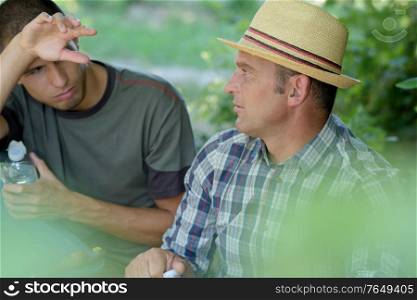 tired farmer in the vineyard talking to manager