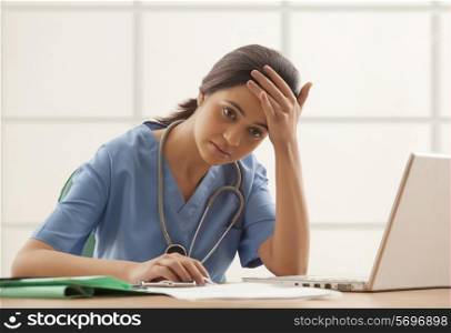 Tired female surgeon at desk