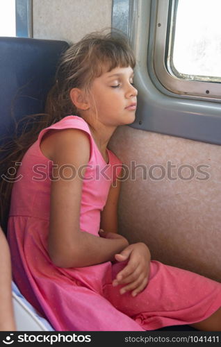 Tired girl fell asleep in an electric train