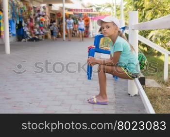 Tired girl sits about six years of trade pavilions with summer goods