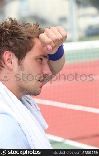 Tired man by tennis court