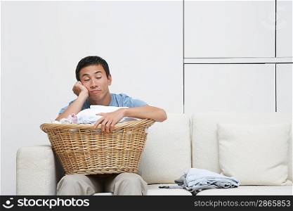 Tired Man with Laundry Resting on Sofa