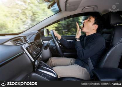 tired man yawning and sleepy while driving a car