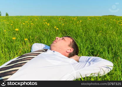 tired manager resting on green grass in field