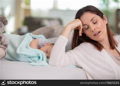 tired mother with baby boy at home