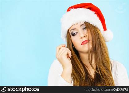 Tired sad woman wearing santa hat. Female with lack of energy. Christmas time.. Tired woman wearing santa hat