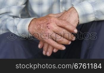 Tired scraped hands of elderly farmer