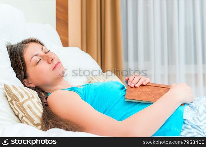 tired student sleeps with a book in hand
