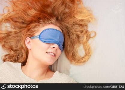 Tired woman sleeping in bed wearing blindfold sleep mask. Young girl taking nap.. Sleeping woman wearing blindfold sleep mask.