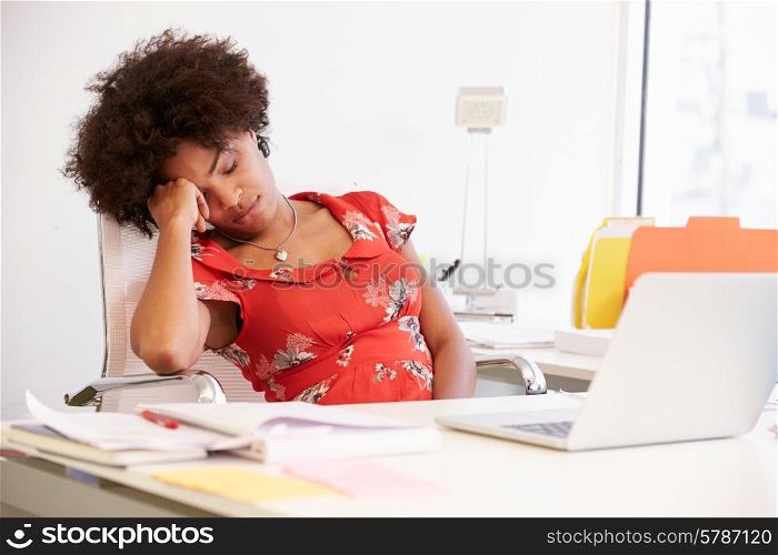 Tired Woman Working At Desk In Design Studio