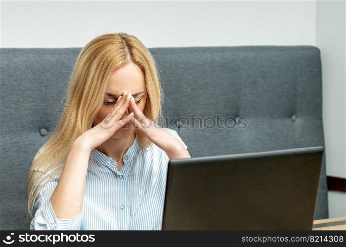 Tired young business woman sitting in front of laptop at office.. Tired business woman at office.