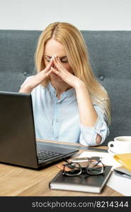 Tired young business woman sitting in front of laptop at office.. Tired business woman at office.