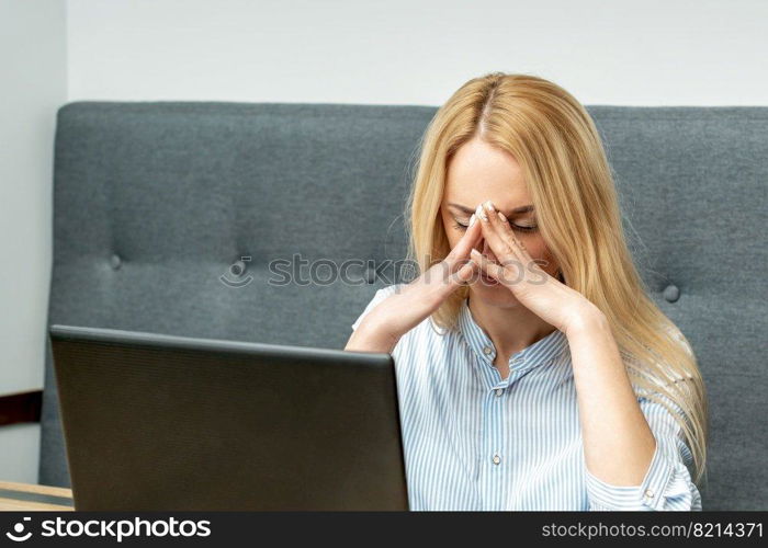 Tired young business woman sitting in front of laptop at office.. Tired business woman at office.