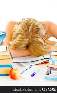 Tired young girl sleeping at table with piles of books&#xA;
