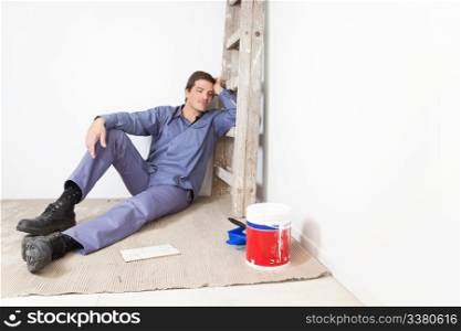 Tired young man leaning on ladder and sleeping