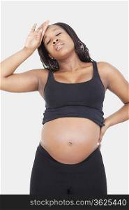 Tired young pregnant woman over white background